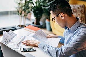 man with glasses reading over financial documents