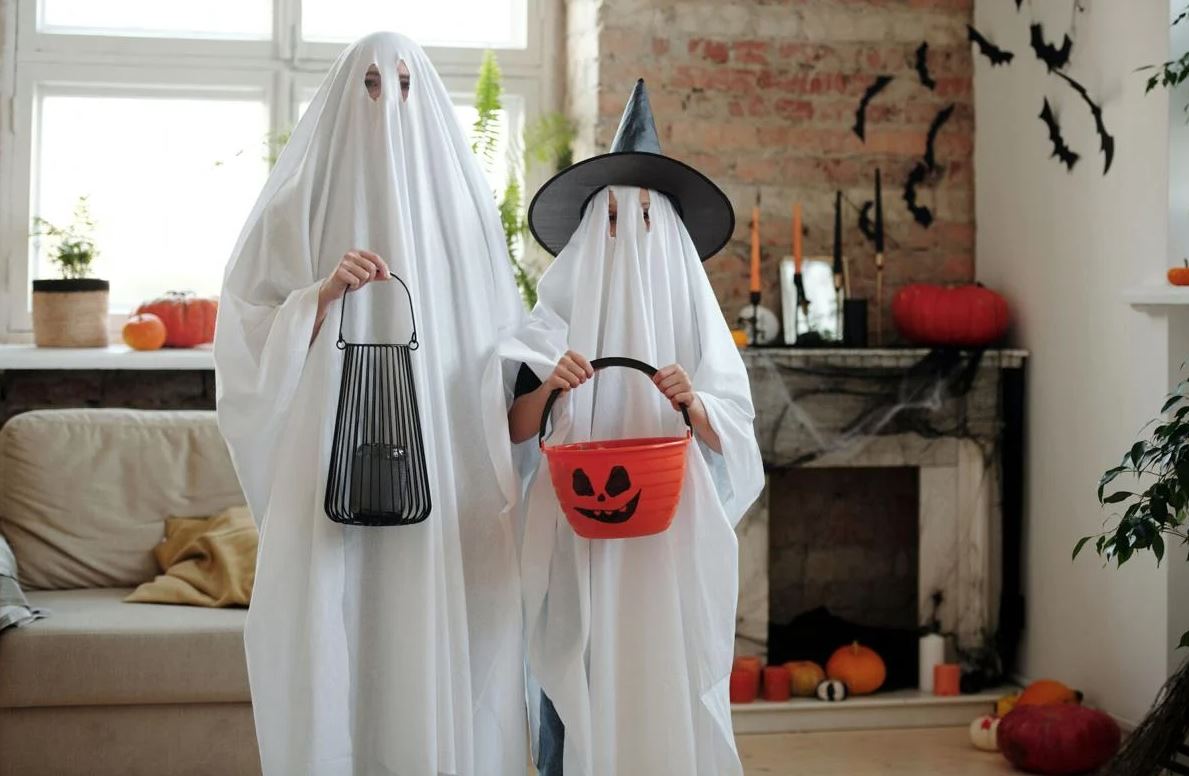 Two individuals in ghost costumes.