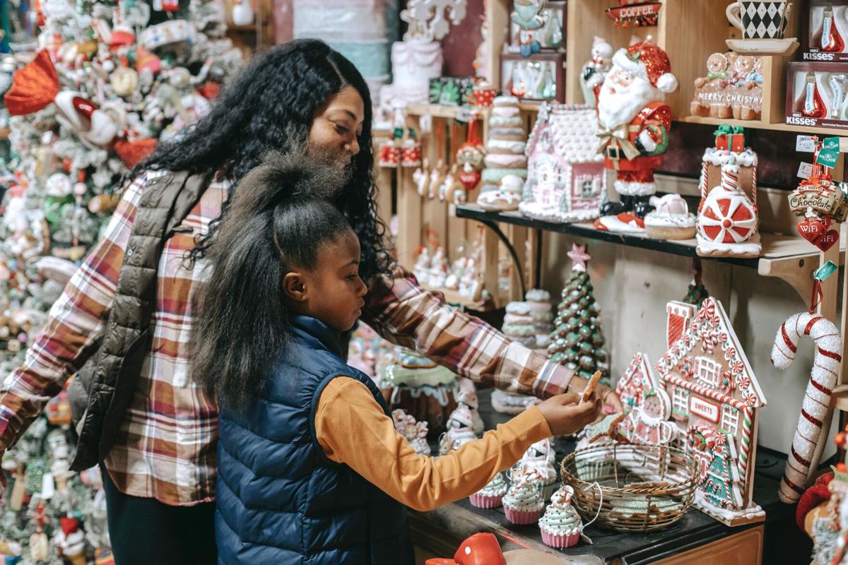 A mother and her daughter gaze at Christmas decorations.