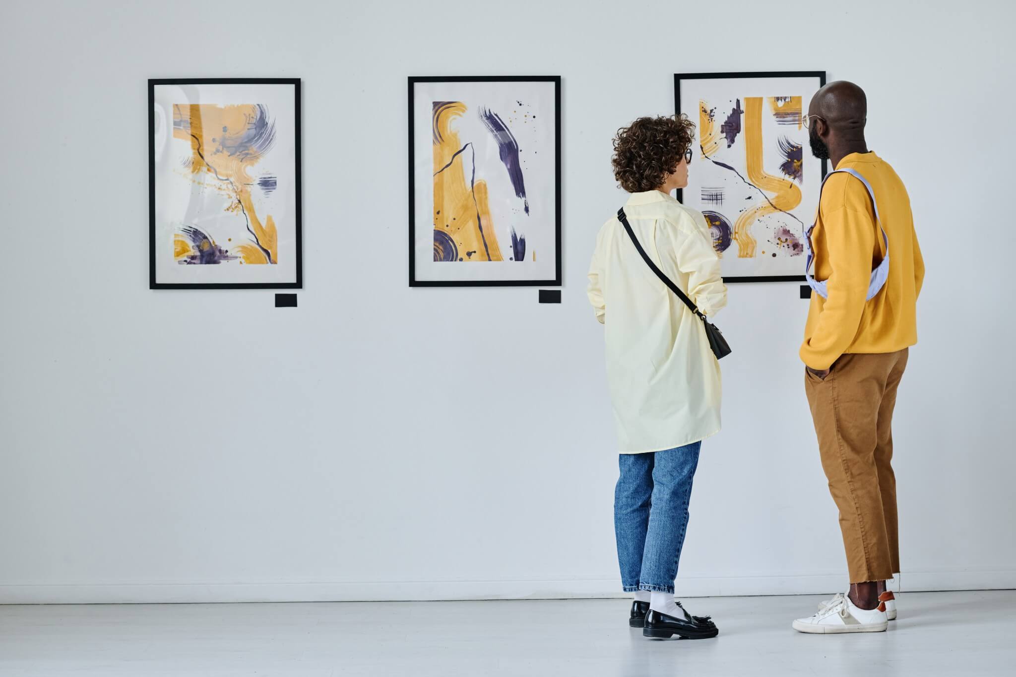 Two visitors exploring an art gallery.