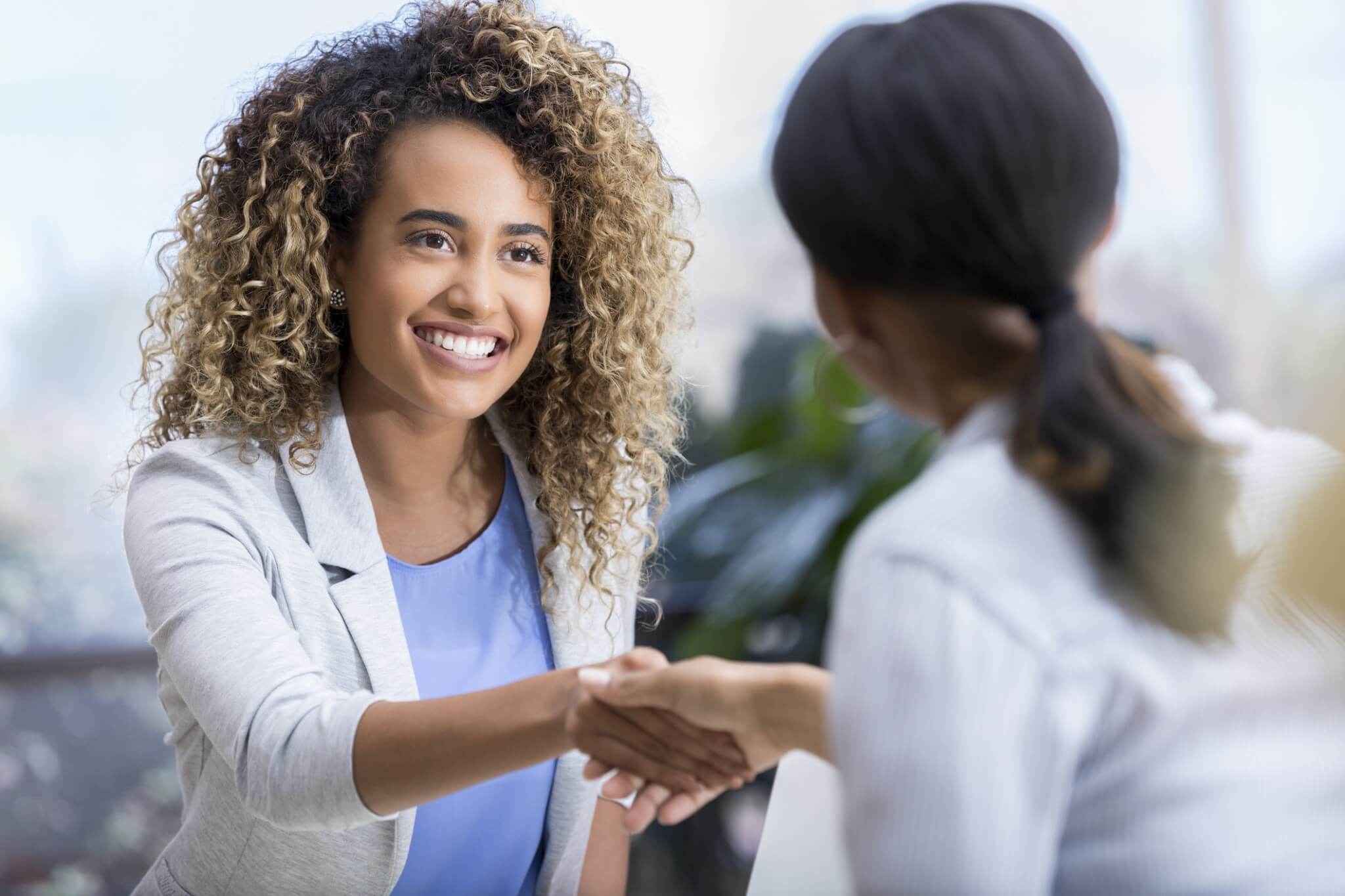 Two Women shaking hands.