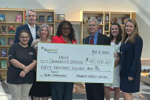 A group of people indoors holding a large check for $40,000.