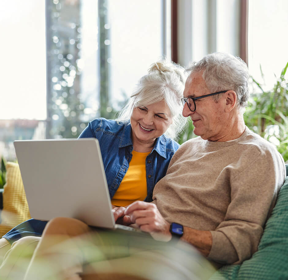 old-couple-happily-using-laptop