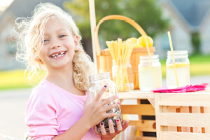 A young girl joyfully holds a jar.