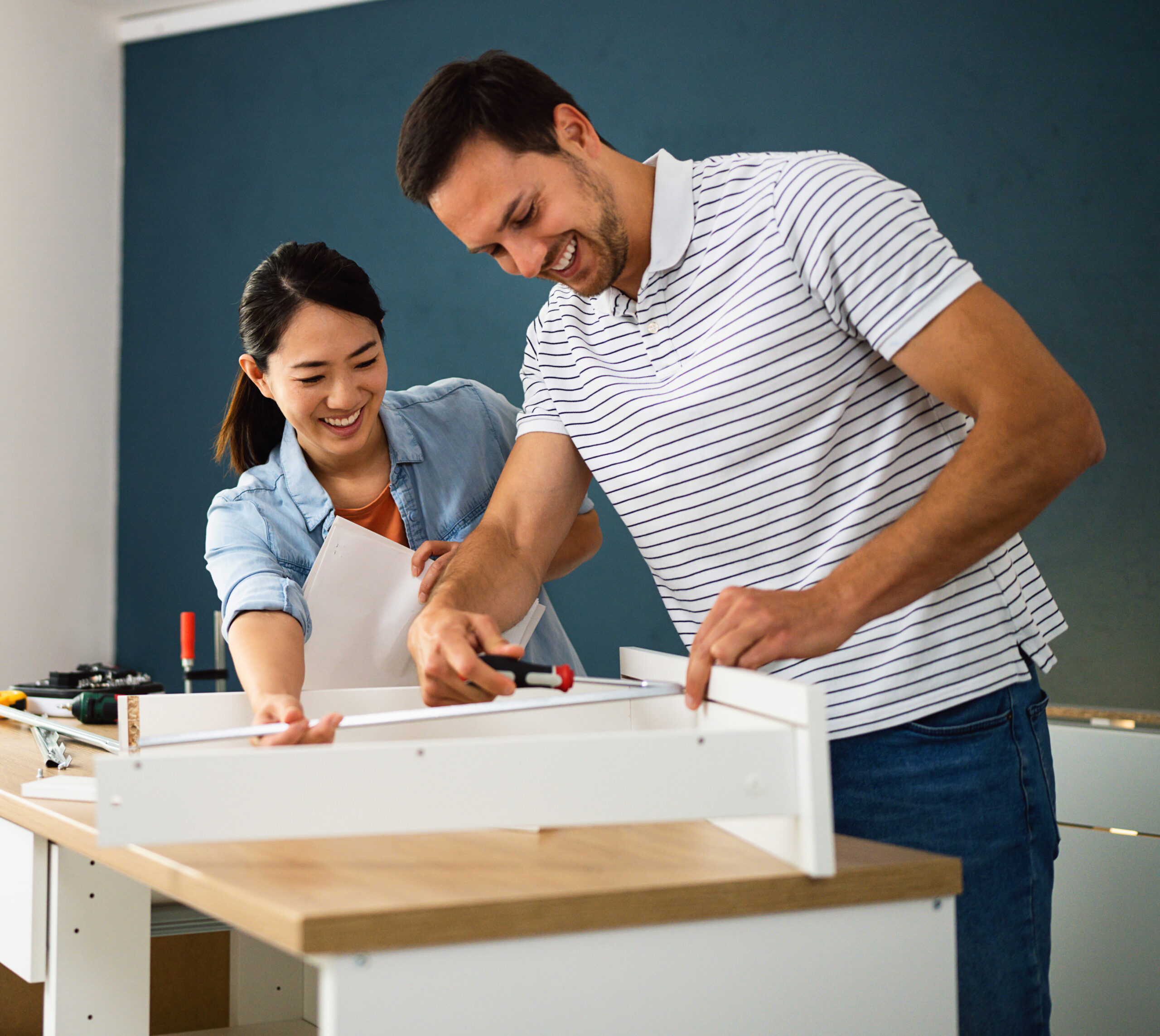 Couple assembling furniture together at their new home