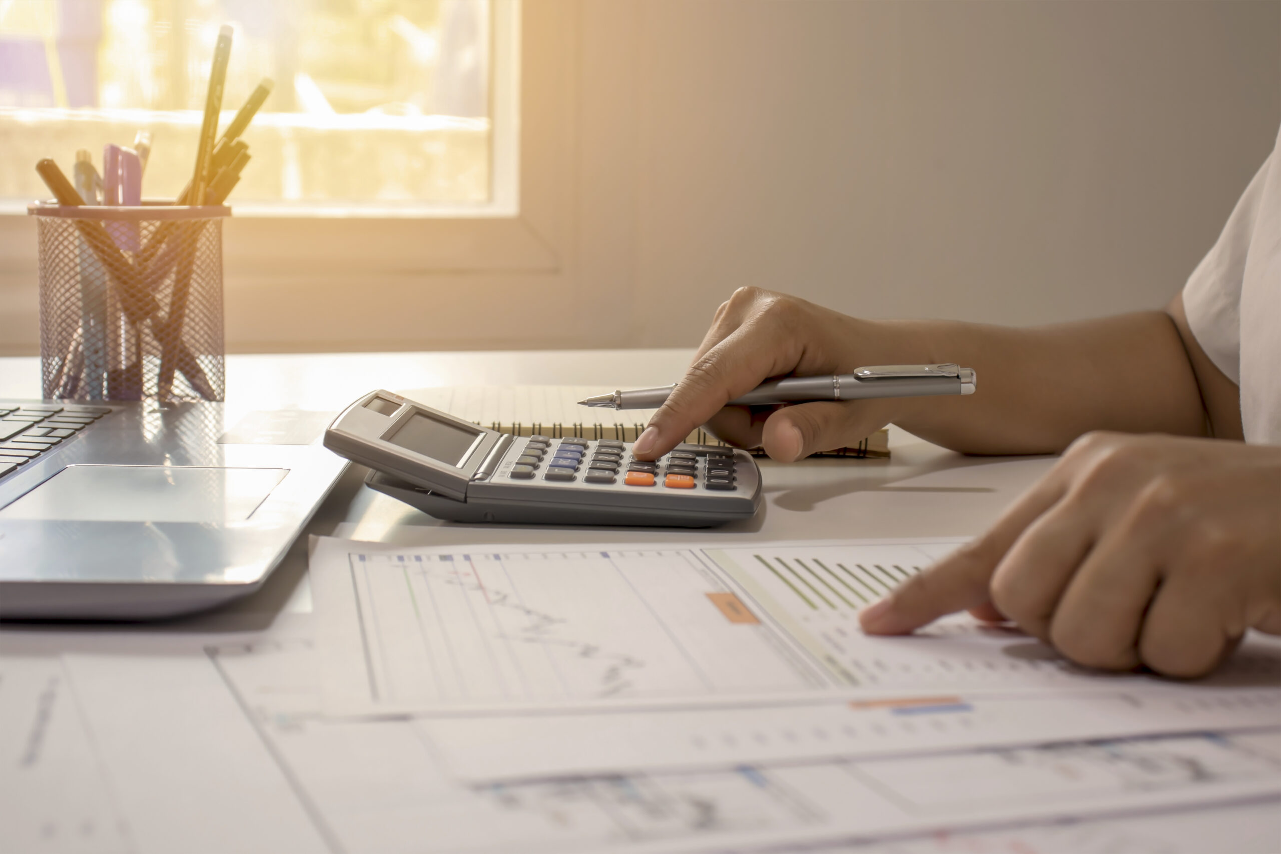 close-up of a man pressing on a calculator