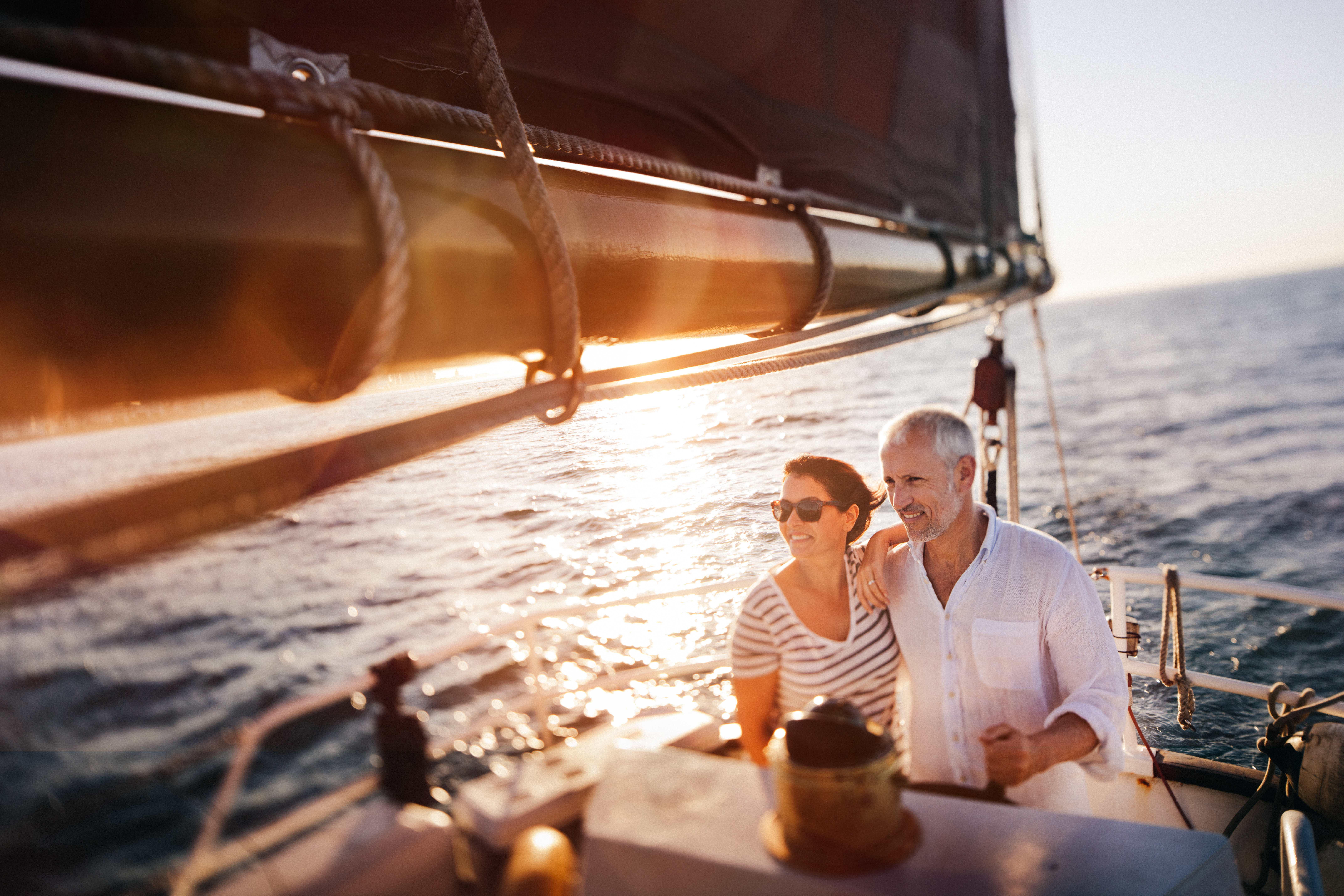 Senior active couple enjoying the fresh ocean breeze on their yacht