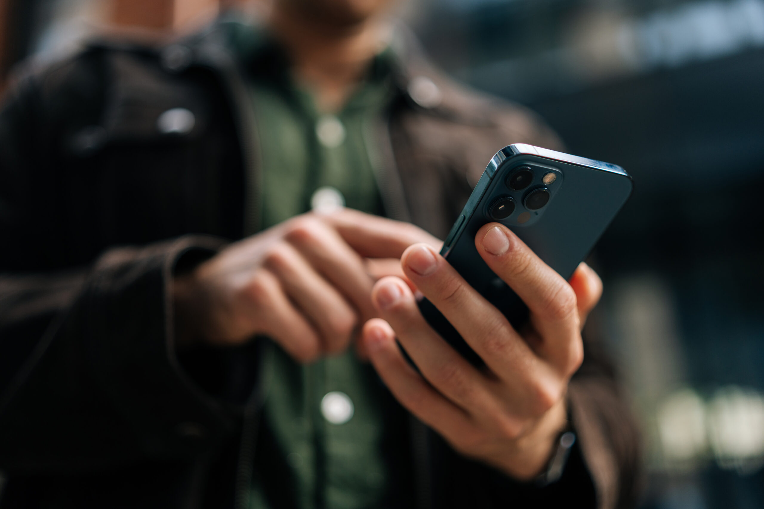 close up of a man's hands holding an iphone